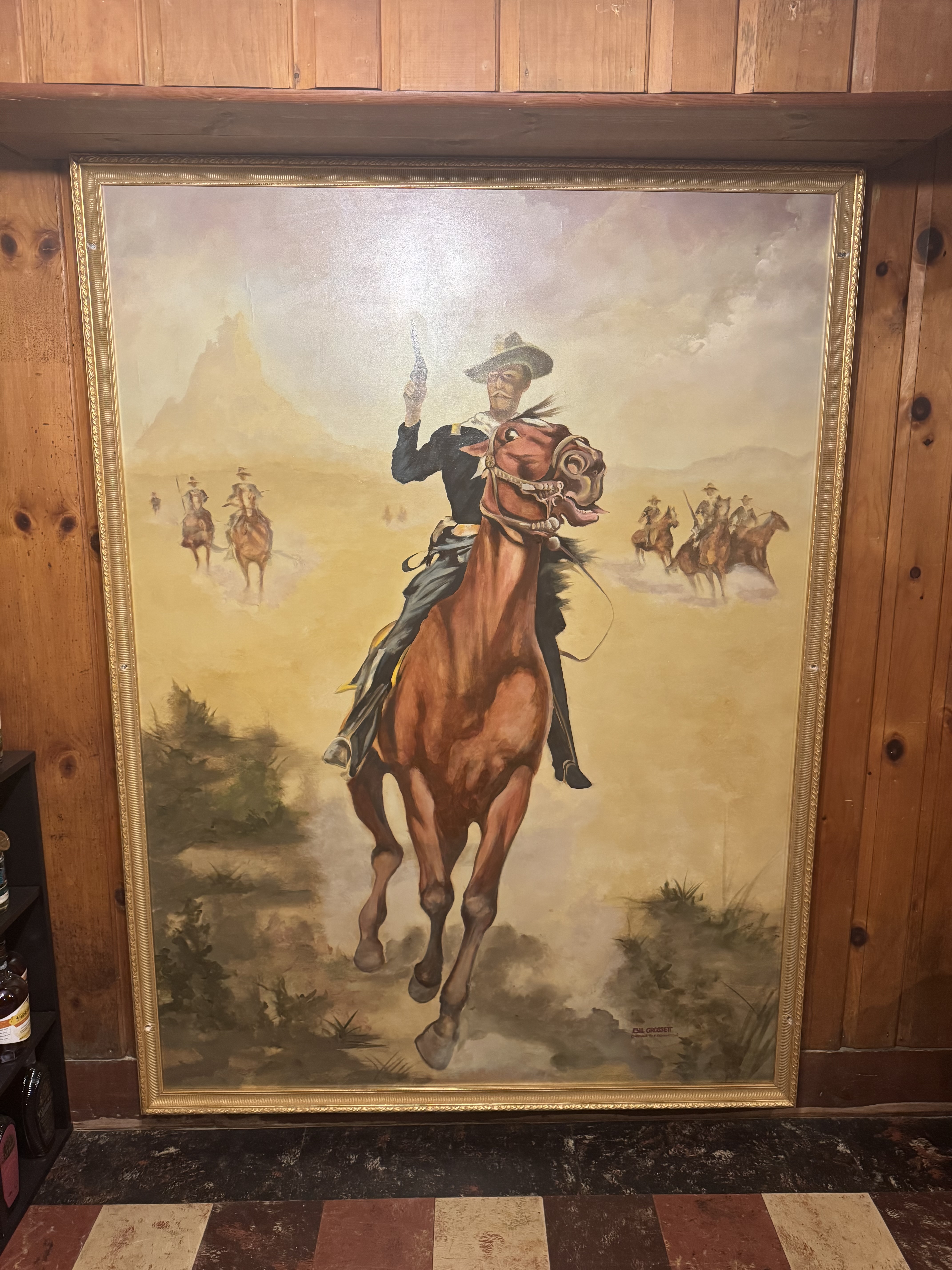 Cowboy painting on wood-paneled wall