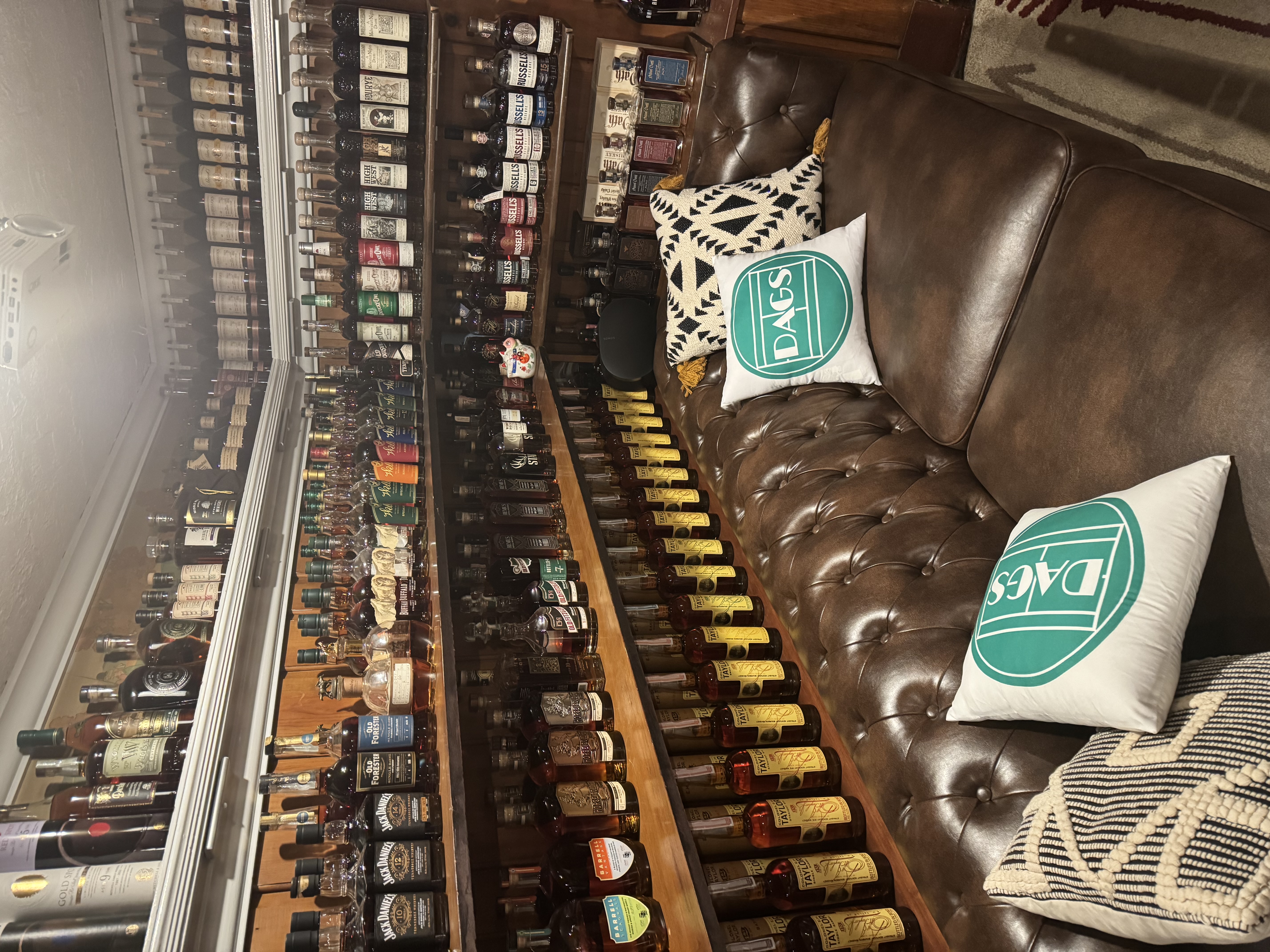 Main lounge couch with pillows and bottle wall