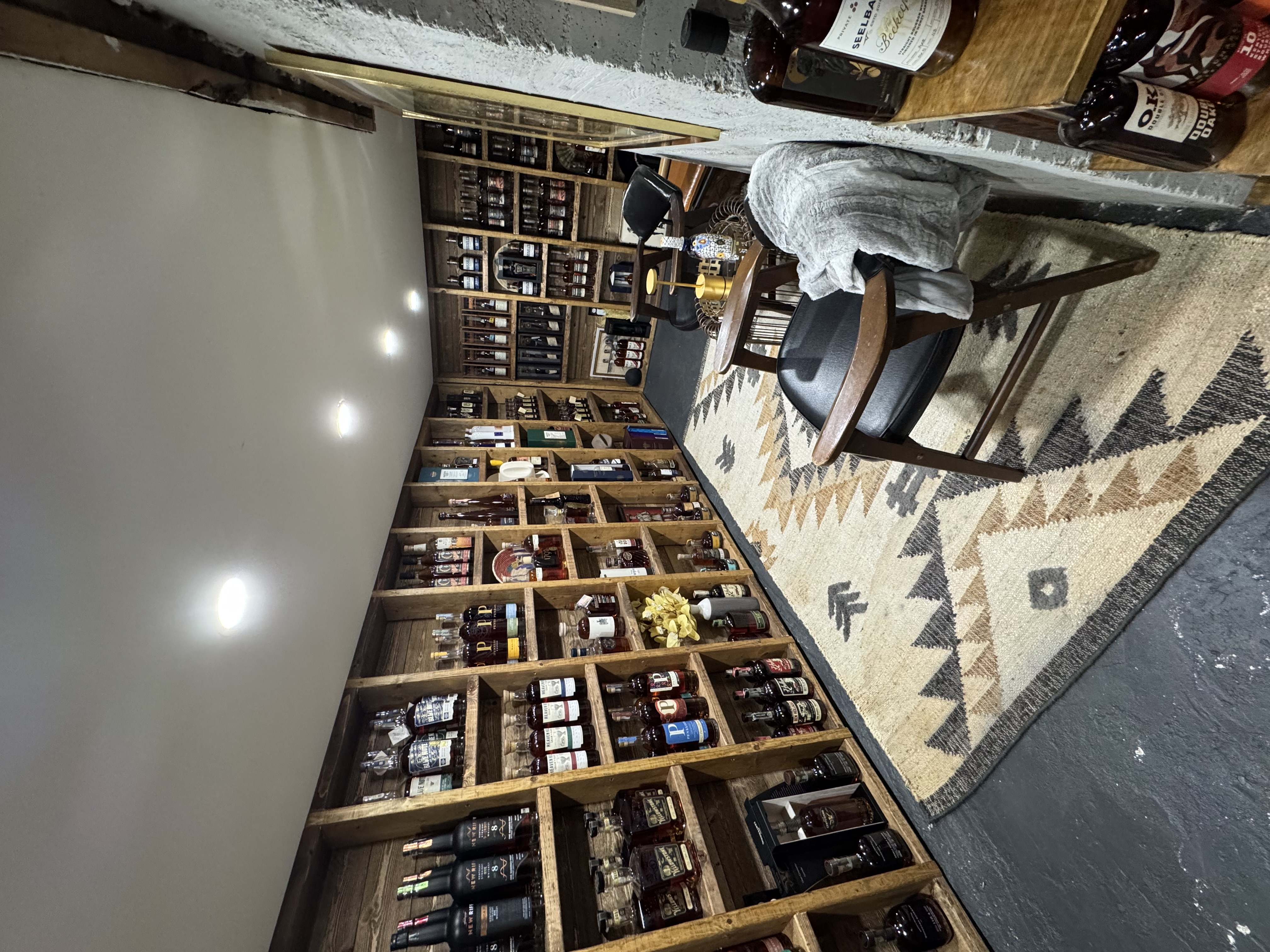 Bottle room shelves with chairs and rug
